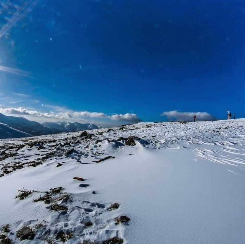 Яркое солнце над заснеженными горными склонами Бакуриани зимой
