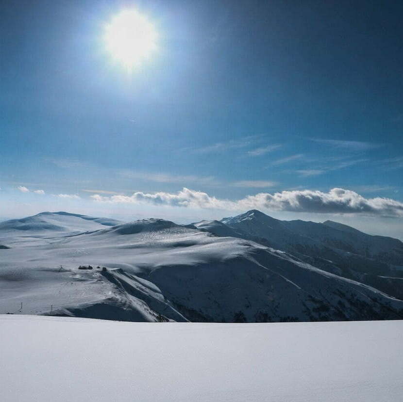 Бескрайние снежные поля и панорама гор Самцхе-Джавахети в ясный зимний день
