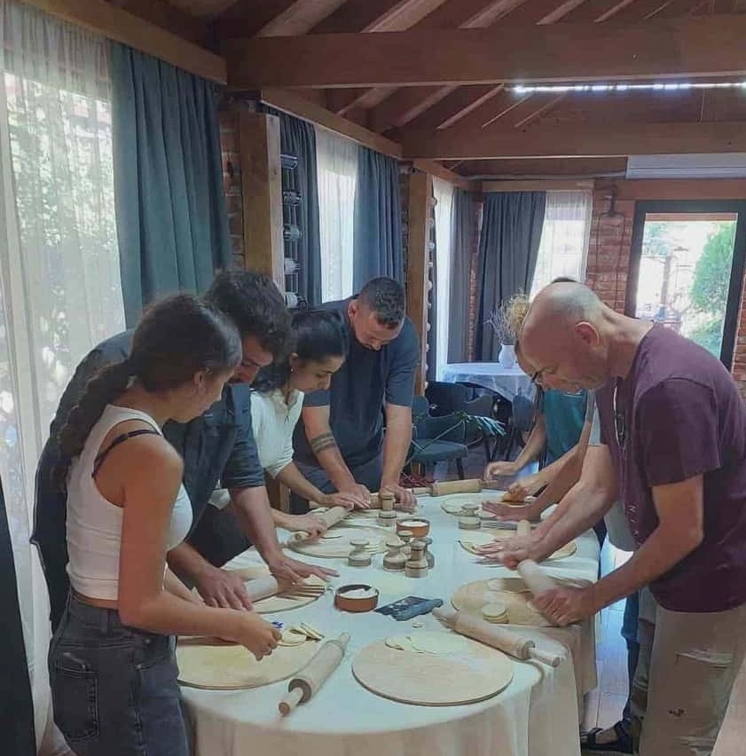 authentic Georgian cooking masterclasses & wine tasting in Kutaisi tourists participating in a hands-on Georgian food masterclasses in Kutaisi, kneading dough for traditional Khachapuri and Khinkali. A culinary experience by zuratour.com