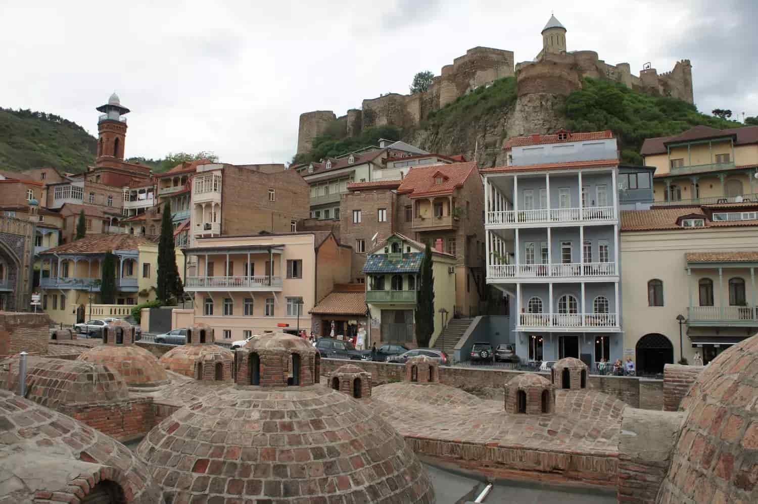 ancient history and Georgian architecture with zura tour view of Narikala fortress towering over the traditional wooden balconies of old tbilisi -zuratour.com tours