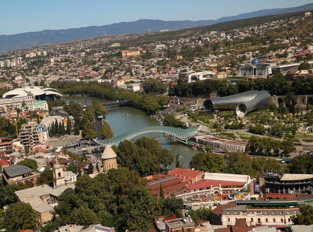 Панорамный вид на реку Куру стеклянный мост Мира и старый город с высоты